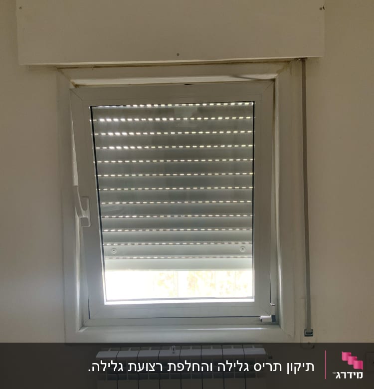 תריסים חצי סגורים על חלון עם מסגרת לבנה